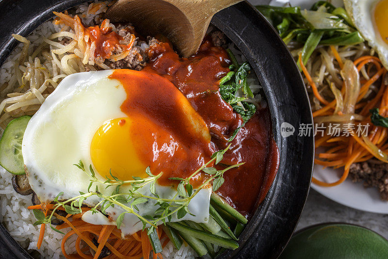 BI Bim Bap，拌菜饭，顶视图与热酱在铸铁锅